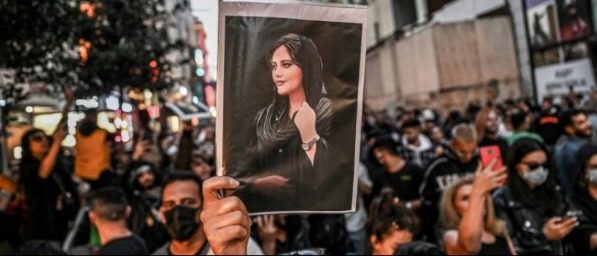 Une manifestante brandit le portrait de Mahsa Amini